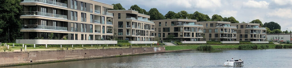 Gebäude aus Sperrbetonkonstruktionen an einem Flussufer.